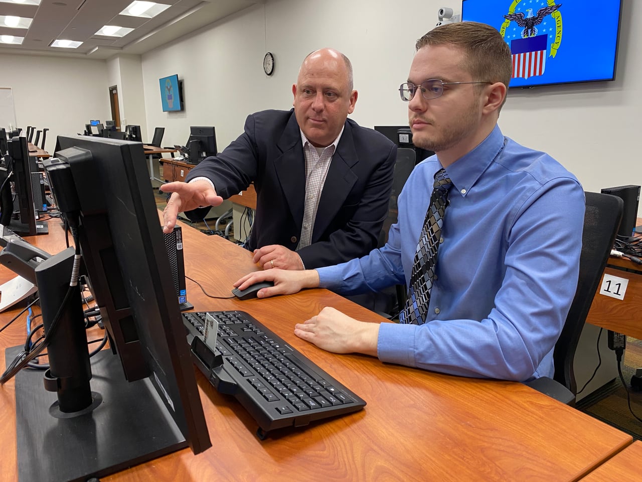 A Feith solutions engineer walking a colleague through records management at a workstation